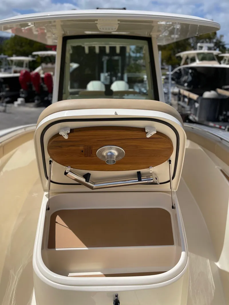 Slide: The Image of 2026 Scout 305 LXF boat with open storage compartment lid. - 8