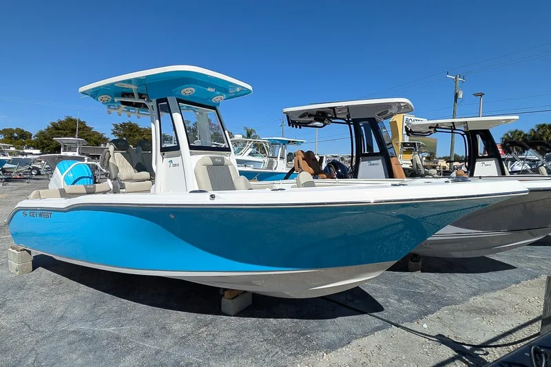 The Image of 2026 Key West 239 FS boat with blue hull, parked outdoors under clear sky. - 0