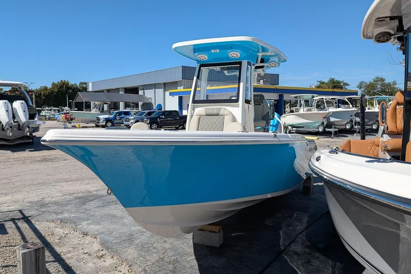 Slide: The Image of 2026 Key West 239 FS boat in vibrant blue, displayed outdoors at a dealership. - 2