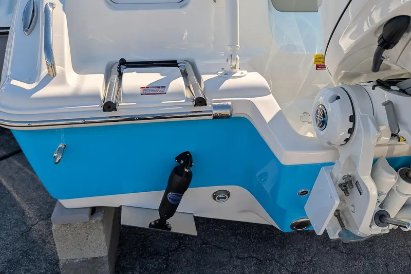 Slide: The Image of 2026 Key West 239 FS boat stern with motor and ladder, blue and white design. - 5