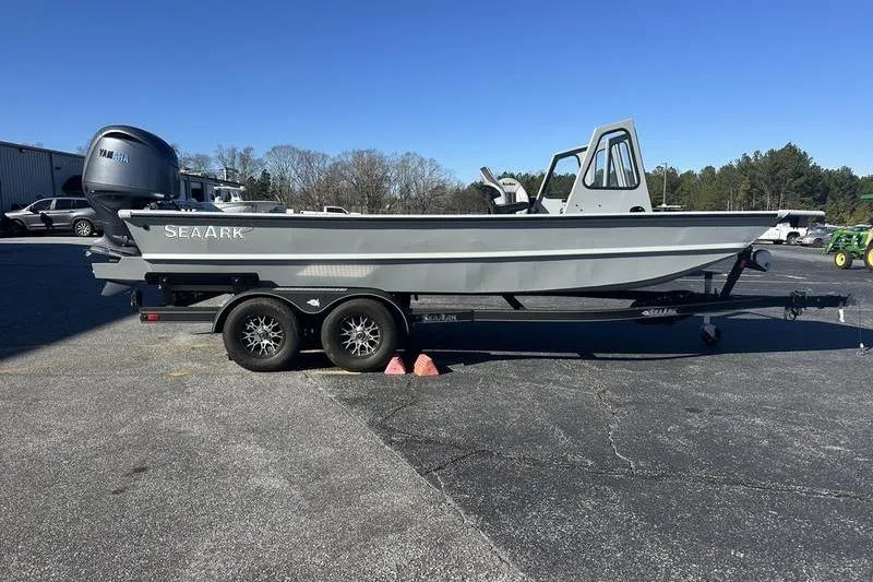 The Image of 2025 SeaArk 2072 MVT boat on trailer, parked outdoors under clear blue sky. - 0