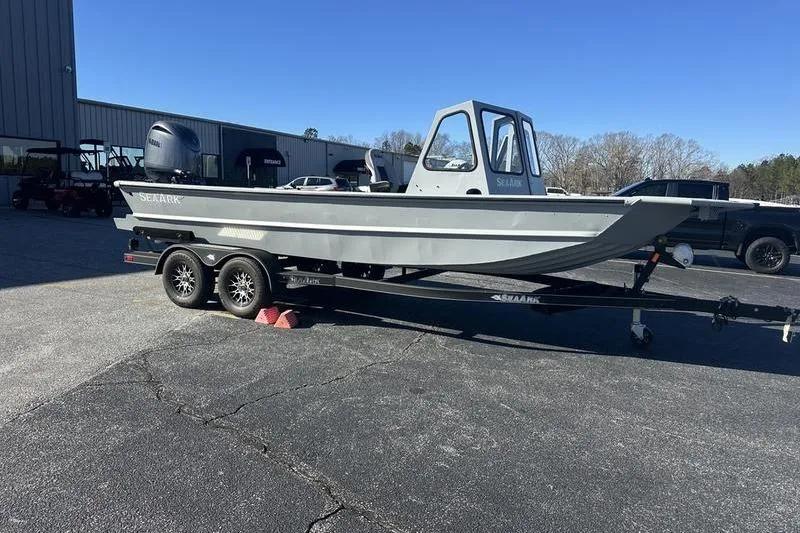 Slide: The Image of 2025 SeaArk 2072 MVT boat on trailer, parked outdoors under clear blue sky. - 2