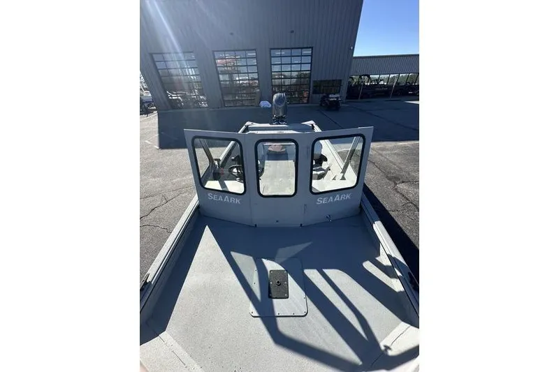 Slide: The Image of 2025 SeaArk 2072 MVT boat with cabin, parked outside a building on a sunny day. - 4