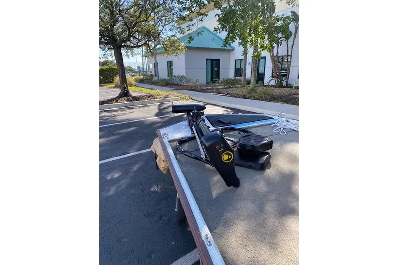 Slide: The Image of 2022 Tracker Bass Tracker Classic XL boat parked outdoors near trees and building. - 10