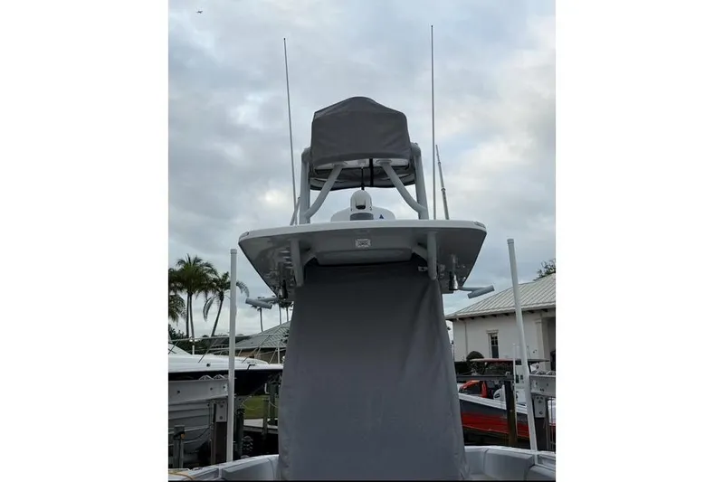 Slide: The Image of 2024 SeaHunter 28 Floridian boat with covered tower, docked under cloudy skies. - 5