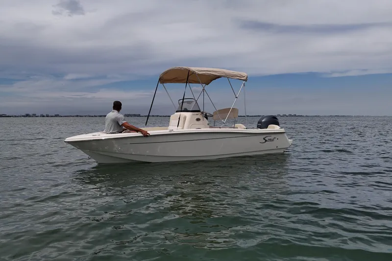 Slide: The Image of 2026 Scout 188 Sportfish boat on calm water under cloudy sky. - 8