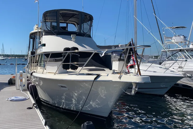 The Image of 1991 Hatteras 40 Motor Yacht docked at marina on a sunny day. - 1