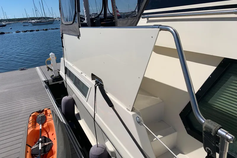 Slide: The Image of 1991 Hatteras 40 Motor Yacht docked with kayak, sunny marina view. - 103