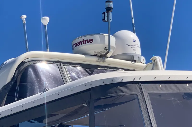 Slide: The Image of 1991 Hatteras 40 Motor Yacht with radar and satellite equipment under clear blue sky. - 105