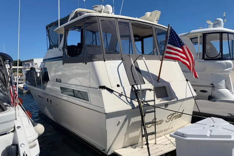 Slide: The Image of 1991 Hatteras 40 Motor Yacht docked with American flag, sunny day. - 106