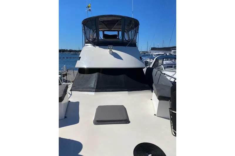 Slide: The Image of 1991 Hatteras 40 Motor Yacht on water, featuring spacious deck and sleek design. - 12