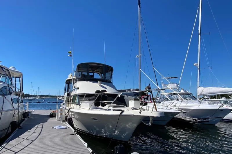 Slide: The Image of 1991 Hatteras 40 Motor Yacht docked at marina under clear blue sky. - 13