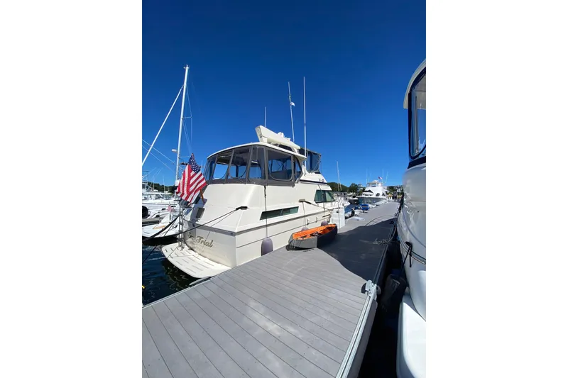Slide: The Image of 1991 Hatteras 40 Motor Yacht docked at marina under clear blue sky. - 17