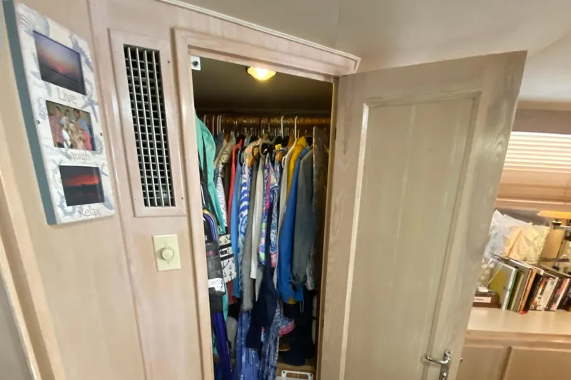 Slide: The Image of Closet interior on 1991 Hatteras 40 Motor Yacht with clothes and decor. - 27