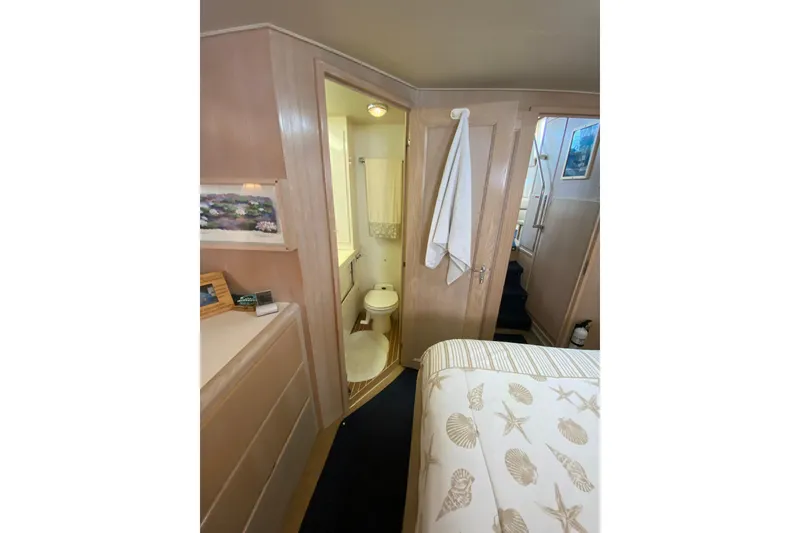Slide: The Image of 1991 Hatteras 40 Motor Yacht interior with bathroom, cozy bedroom, and nautical decor. - 29