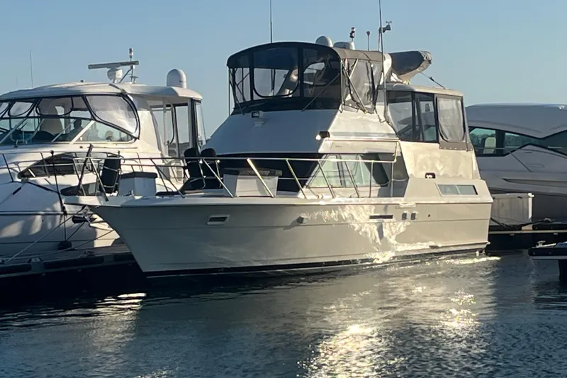 Slide: The Image of 1991 Hatteras 40 Motor Yacht docked in marina, reflecting sunlight on water. - 3