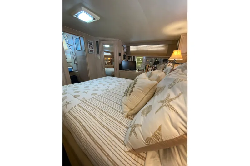 Slide: The Image of Cozy bedroom interior of 1991 Hatteras 40 Motor Yacht with nautical-themed bedding. - 31