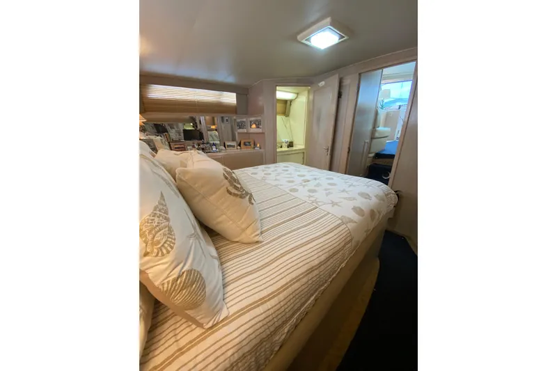 Slide: The Image of Cozy bedroom interior of 1991 Hatteras 40 Motor Yacht with nautical-themed bedding. - 32