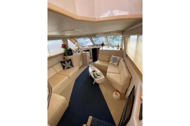 Slide: The Image of Luxurious interior of a 1991 Hatteras 40 Motor Yacht with beige seating and nautical decor. - 36