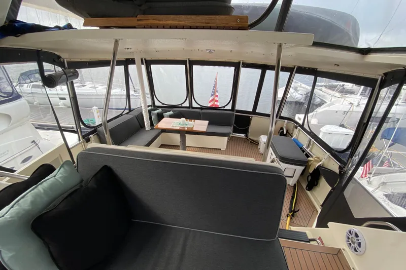 Slide: The Image of Interior of 1991 Hatteras 40 Motor Yacht with seating and table, docked at marina. - 49