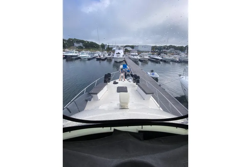 Slide: The Image of 1991 Hatteras 40 Motor Yacht docked at a marina on a rainy day. - 50