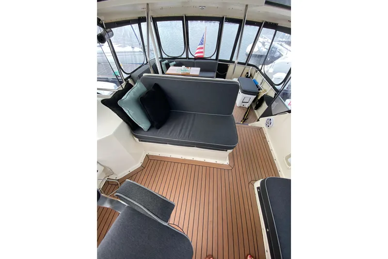 Slide: The Image of 1991 Hatteras 40 Motor Yacht interior with cushioned seating and wooden flooring. - 51