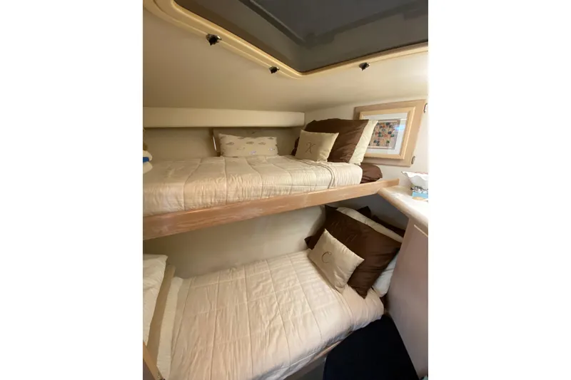 Slide: The Image of 1991 Hatteras 40 Motor Yacht interior with cozy bunk beds and decorative pillows. - 54