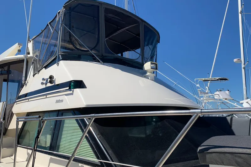 Slide: The Image of 1991 Hatteras 40 Motor Yacht with sleek design, docked under clear blue sky. - 6