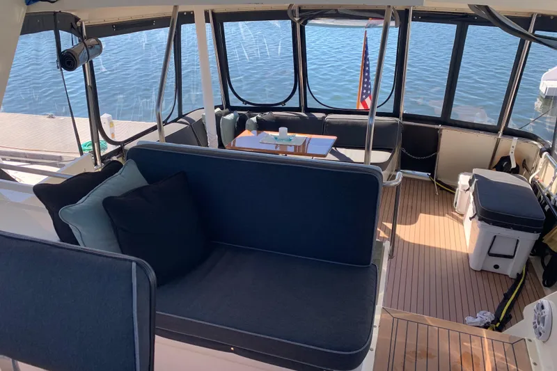 Slide: The Image of 1991 Hatteras 40 Motor Yacht interior with seating, table, and lake view. - 63