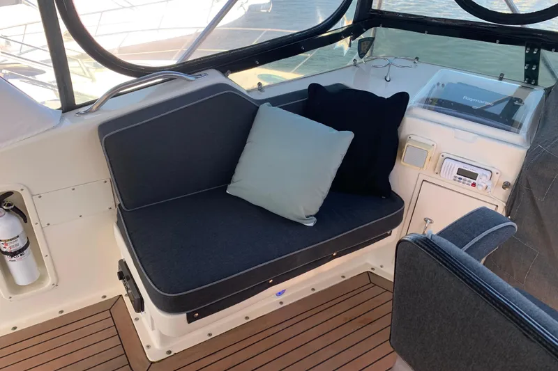 Slide: The Image of 1991 Hatteras 40 Motor Yacht interior with cushioned seating and navigation equipment. - 64