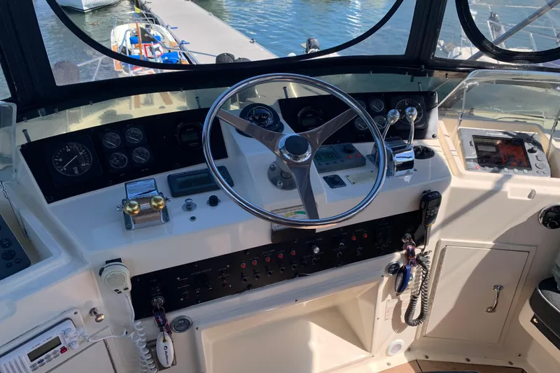 Slide: The Image of Control panel of a 1991 Hatteras 40 Motor Yacht with steering wheel and navigation instruments. - 67