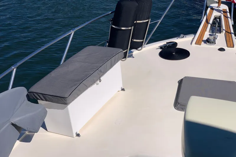 Slide: The Image of 1991 Hatteras 40 Motor Yacht deck with seating and railing, on calm water. - 78