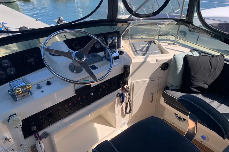 Slide: The Image of 1991 Hatteras 40 Motor Yacht helm with steering wheel and control panel. - 84