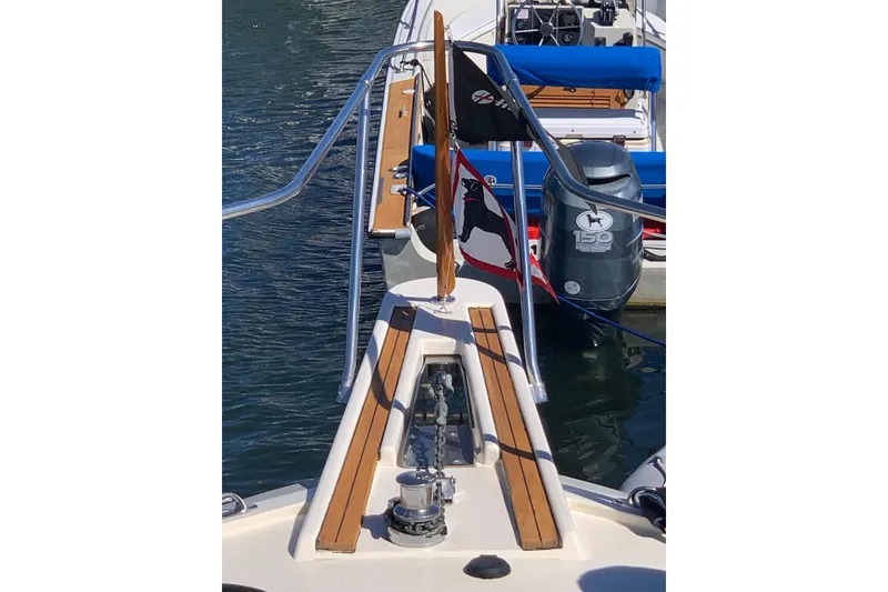 Slide: The Image of 1991 Hatteras 40 Motor Yacht bow with anchor and flags in marina. - 86