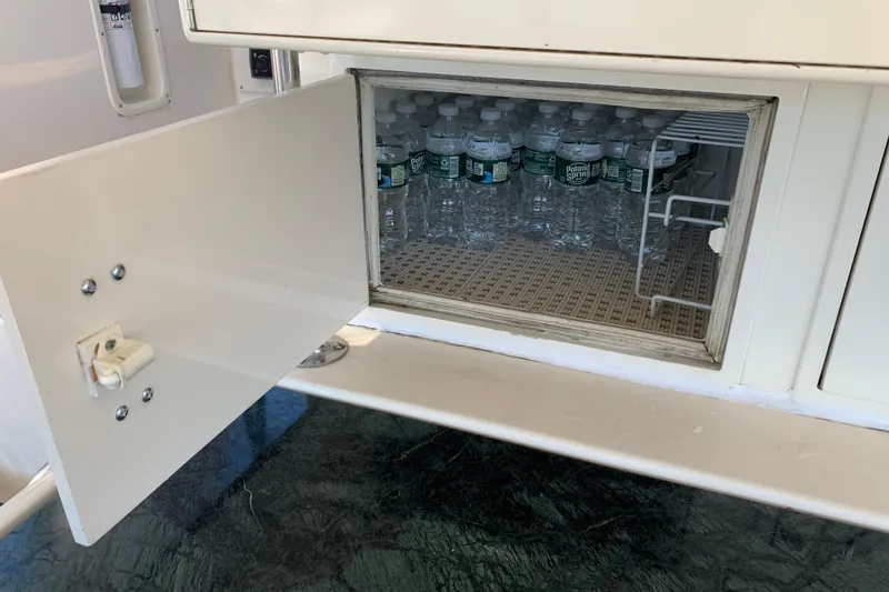 Slide: The Image of Open cabinet on 1991 Hatteras 40 Motor Yacht with water bottles inside. - 89