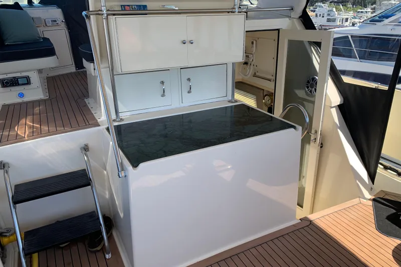 Slide: The Image of 1991 Hatteras 40 Motor Yacht interior with stairs, cabinets, and seating area. - 90