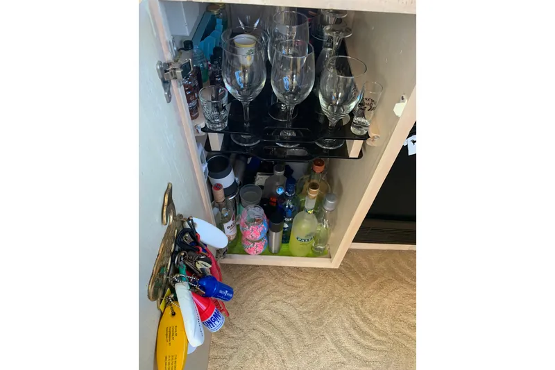 Slide: The Image of Bar cabinet on 1991 Hatteras 40 Motor Yacht with glasses and assorted bottles. - 93