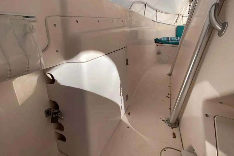 Slide: The Image of 1999 Grady-White Chase 263 boat interior with storage compartment and seating area. - 15
