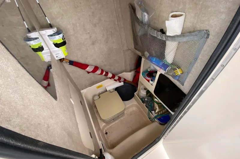 Slide: The Image of 1999 Grady-White Chase 263 boat interior with storage and fishing gear. - 17