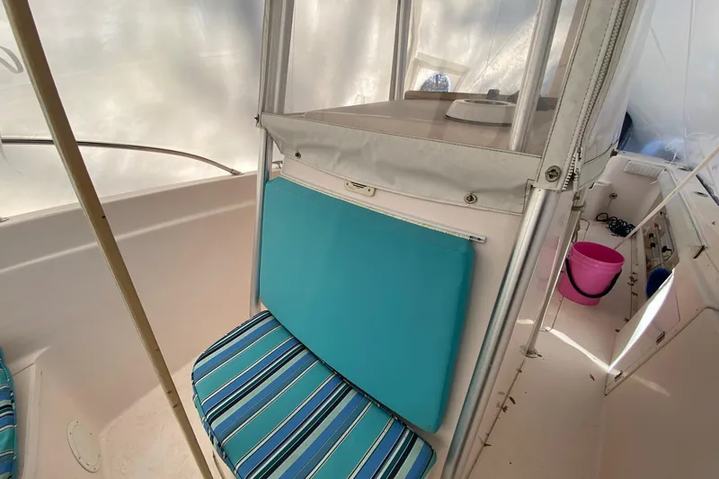 Slide: The Image of Interior of a 1999 Grady-White Chase 263 boat with striped seating and pink bucket. - 18