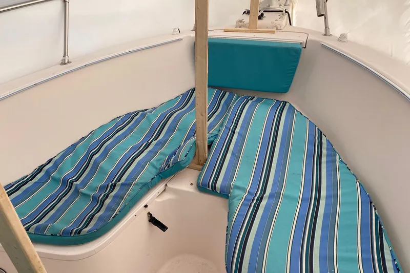 Slide: The Image of 1999 Grady-White Chase 263 boat interior with striped blue cushions. - 19