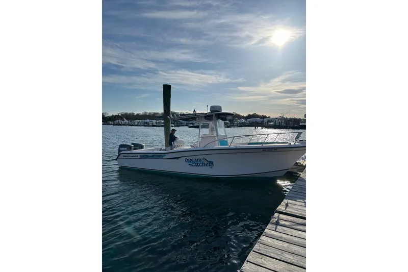 Slide: The Image of 1999 Grady-White Chase 263 boat docked under a sunny sky. - 2