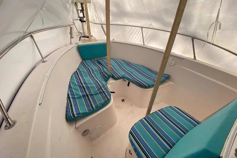 Slide: The Image of 1999 Grady-White Chase 263 boat interior with striped cushions and white canopy. - 21