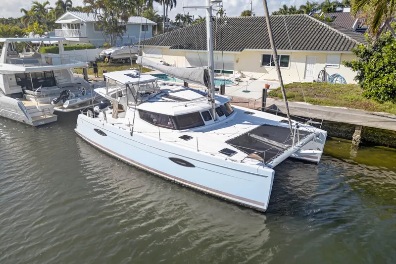 The Image of 2014 Fountaine Pajot Helia 44 catamaran docked by waterfront home. - 0