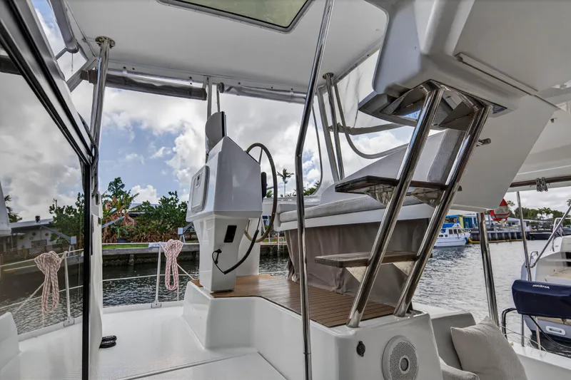 Slide: The Image of 2014 Fountaine Pajot Helia 44 yacht helm station with stairs and waterfront view. - 16