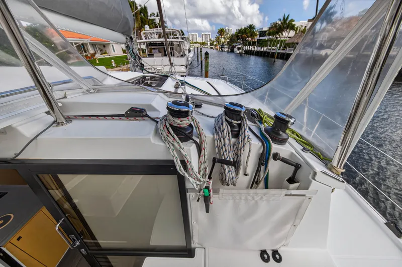 Slide: The Image of 2014 Fountaine Pajot Helia 44 catamaran deck with ropes and winches, docked by a canal. - 22