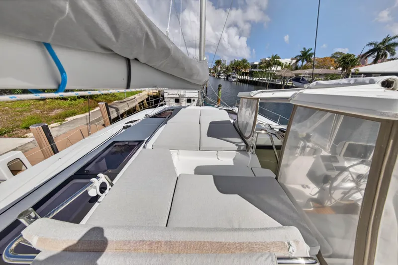 Slide: The Image of 2014 Fountaine Pajot Helia 44 catamaran deck with sun loungers and marina view. - 25