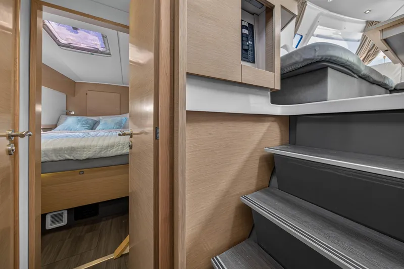 Slide: The Image of Interior of 2014 Fountaine Pajot Helia 44 catamaran, featuring cozy bedroom and modern staircase. - 67
