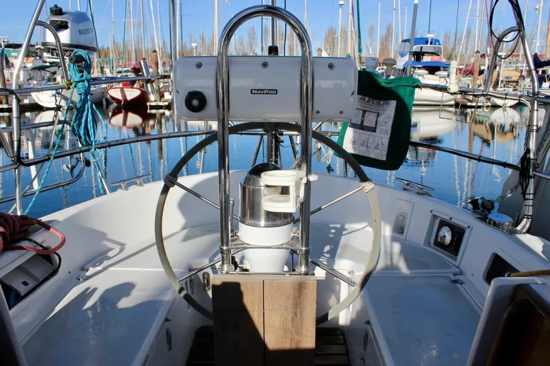 Slide: The Image of Cockpit of a 1997 Valiant 39 sailboat in a marina, featuring steering wheel and equipment. - 22