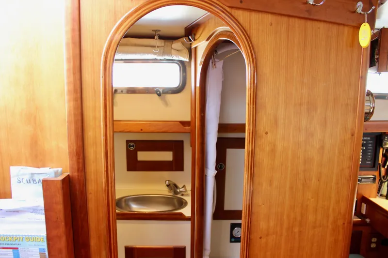 Slide: The Image of Interior of a 1997 Valiant 39 sailboat featuring a wooden bathroom with a sink. - 37